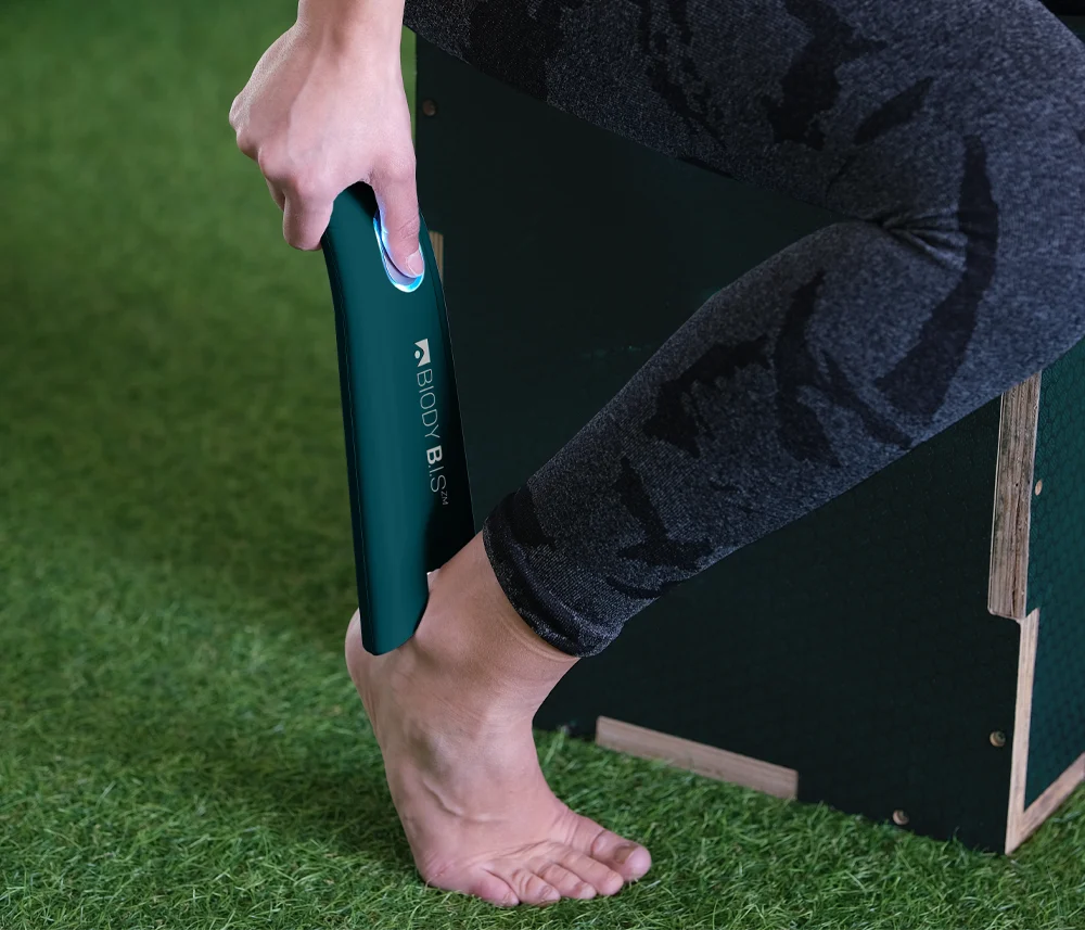 Close-up of the Biody BIS device applied to an ankle for precision bioimpedance analysis in fitness.